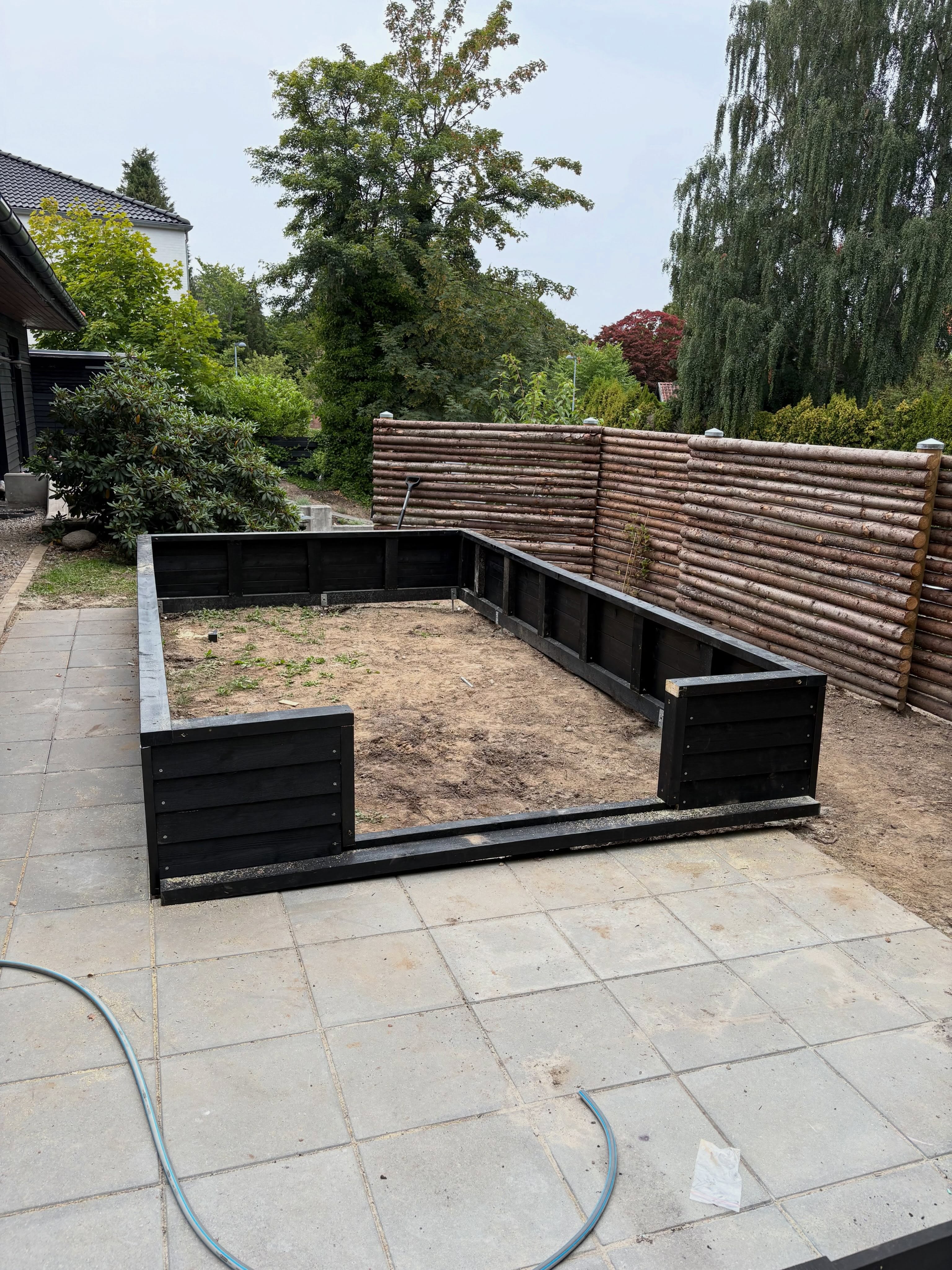 Sortbejdset terrassekonstruktion med plantekasser under opførelse
